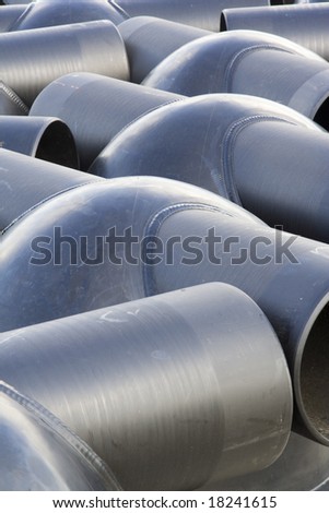 Dark grey rounded pvc sewer drains awaiting underground installation