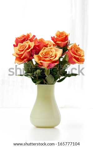a bunch of roses in a green vase