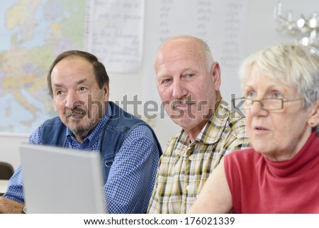 Two old men and a woman with a laptop in front of her.