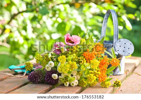 A group of flowers laying next to a watering can.