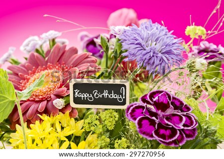 a close up of a bouquet of flowers with a black label saying: Happy Birthday! and a magenta gradient background