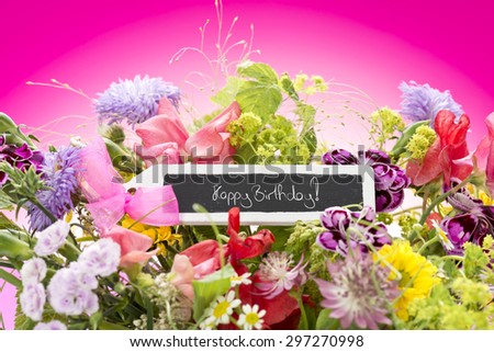 a close up of a bouquet of flowers with a black label saying: Happy Birthday! and a magenta gradient background