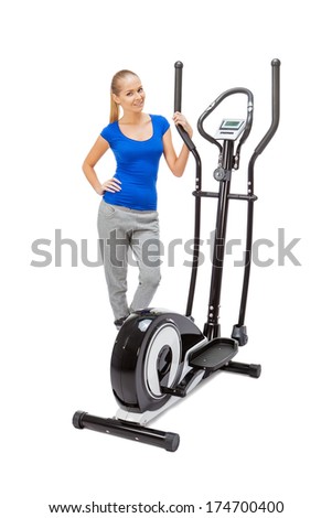 Young woman uses elliptical cross trainer.