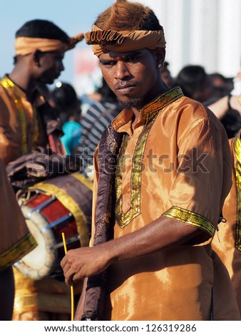 BATU CAVES, MALAYSIA - JANUARY 27:  An unidentified musician beats a mobile drum to accompany devotees during celebration of Thaipusam in Batu Caves, Malaysia on January 27, 2013.