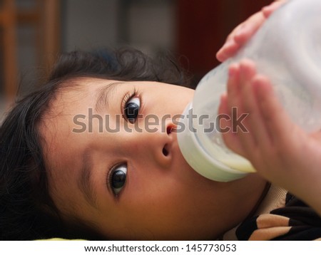 Baby feeding from bottle: Looking away