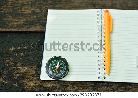 searching direction with a compass and map on wood background