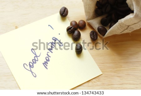 Coffee beans and Good morning note on the wooden desk