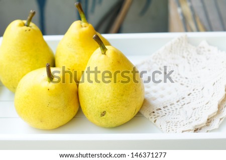 Natural pear juice in a glass bottle and fresh pears on the table