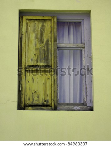 wooden shutters in a window frame of a very old house built from yellow rocks in the village of Signagi, Kakheti region, Georgia (country)