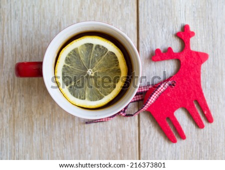 Red ceramic cup with tea and lemon, Happy New Year sign made with chalk, and christmas decoration