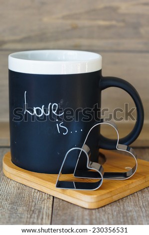 A mug with Love is note and valentine decoration on the wooden table