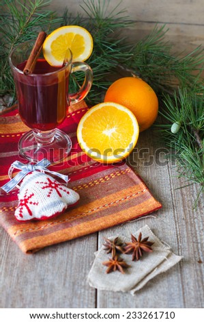 Glass of mulled wine with orange and christmas decor