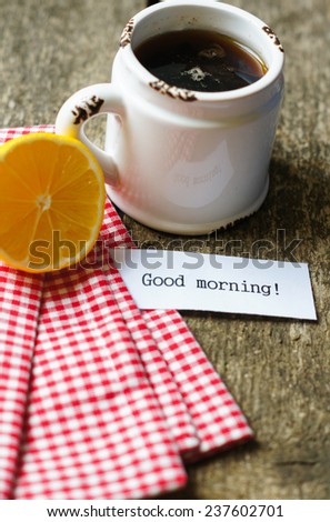Cup of black tea with orange and good morning note