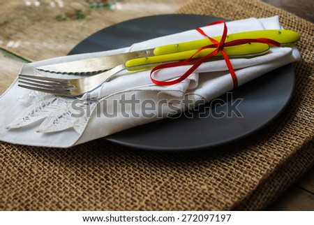 Table Setting with napkin and silverware on wooden table