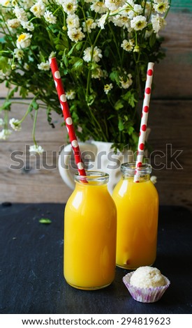 Vintage style bottles with orange juice and straws