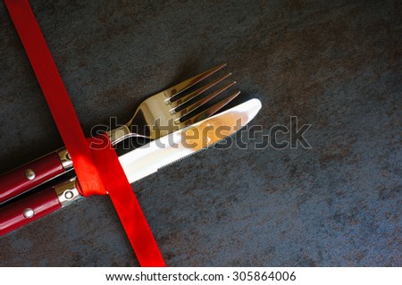 Table set for celebration St. Valentine's Day with red ribbin on dask stone background