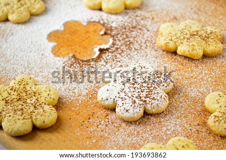 Freshly baked sugar cookies, sprinkled with powdered sugar and cocoa