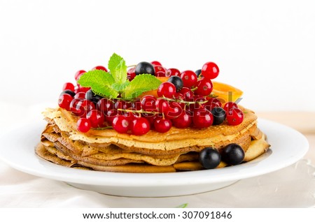Pancakes with berries and fruits. Crepes stack with apricot, red and blackcurrant.