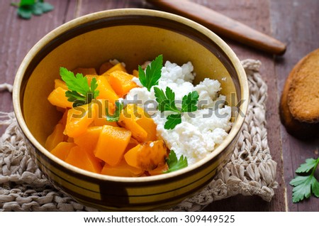 Grilled pumpkin with homemade cheese and herbs on wooden background