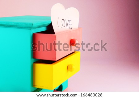 Wording, Love. On pink heart paper note in drawer vintage wood box.