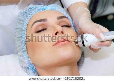 RF lifting procedure on the face of a young woman in a spa salon. Radiofrequency lifting to correct the shape of a young woman's face. Stok fotoğraf © 