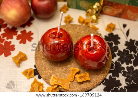 two apple in red caramel on the table