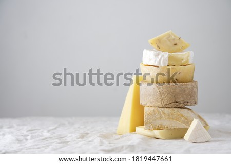 Various kind of cheese, traditional pieces of Spanish, French, Italy cheese. Light background with copy space, table with gray linen tablecloth