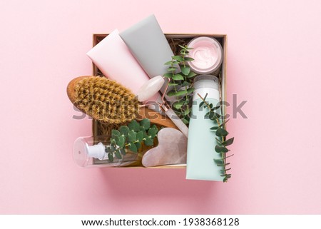 Beauty box with face and body care products on pink background. Tubes with cream and lotion, hydrophilic oil, facial roller, guache massager, body brush. Natural cosmetics gift Foto stock © 