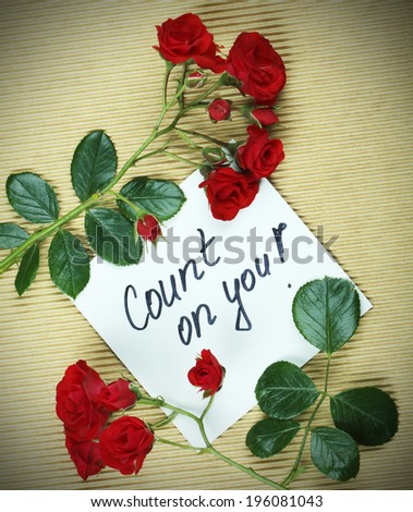 Note count on you hand whriten on white paper in frame maded from roses.
