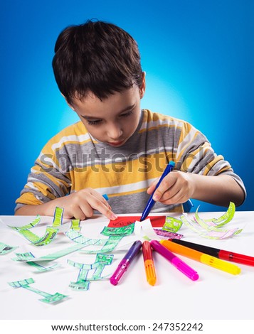 Studio shot of five years old child who is busy with his creative work.