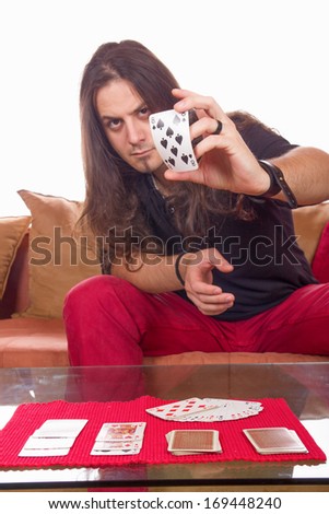 man with a deck of cards on the table showing card