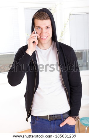 casual handsome man with hooded on the phone in the living room