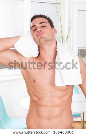sexy naked muscular man with white towel drying hair after bath