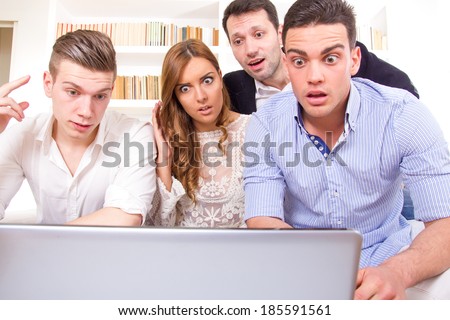 shocked and frustrated casual group of friends sitting on couch looking at laptop, pissed off friends because results, cheering on computer