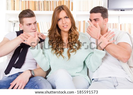 confused and doubtful beautiful woman hesitates between two young guys