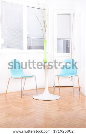 white bright living room interior with decorative flowers on the table with blue chairs, home decor, clean and modern decoration
