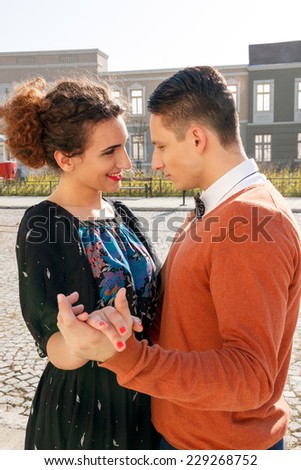 retro man in love with smiling woman looking eye to eye each other in the old town, vintage pasion composition