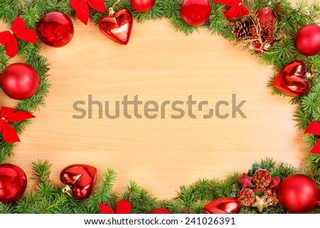 Christmas or New Year decoration with pine or fir and red ornaments balls on wooden texture.  Empty space or place for greeting card text, copy space section