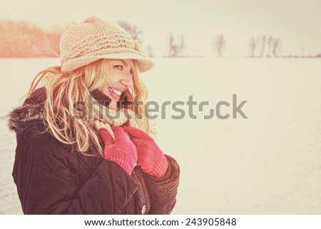 winter happy woman in snow looking aside or to someone, copy space outside on sunny cold winter vintage day. Portrait Caucasian smiling female model with pink gloves in first snow