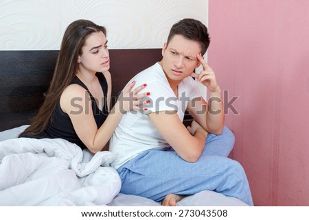 Not in Good Terms Young Couple on Bed. Angry and pissed off man sulking while his woman is explaining herself during fight in bedroom. Understanding and consolation after stubborn quarrel.
