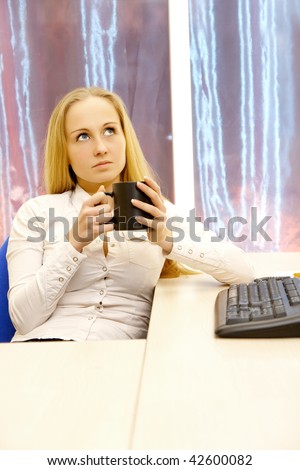 Businesswoman drinks coffee in the office.