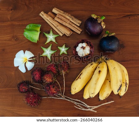 Set of exotic tropical fruits with big pineapple on background lie on wooden table