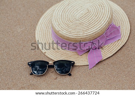 Straw hat, sun glasses on a tropical beach