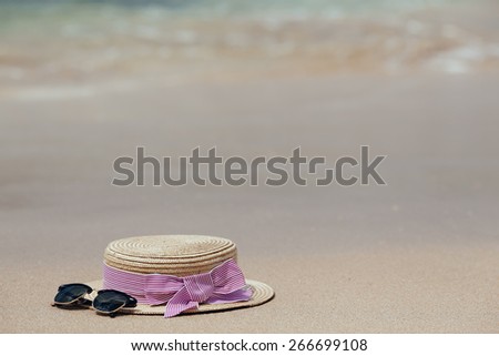 Straw hat, sun glasses on a tropical beach