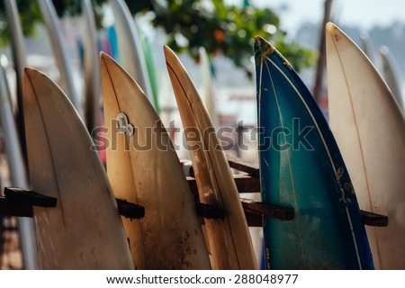 Set of different color surf boards in a stack by ocean.WELIGAMA, SRI LANKA. Surf boards on sandy Weligama beach.  On Weligama beach surf is available all year around for beginner and advanced.