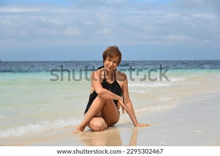 Similar – Foto Bild Ältere Frau am Ufer eines Strandes. Ältere Frau, die ihren Ruhestand an einem Strandort genießt.