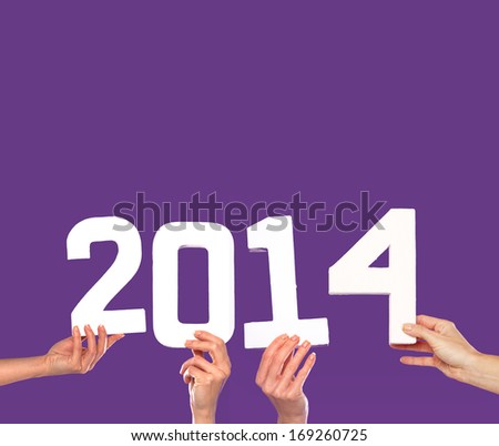2014 New Year greeting card with female hands holding up white numbers forming the date on a purple background with copyspace for your party invitation or seasonal greeting