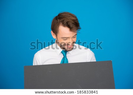 Businessman holding blank poster on blue