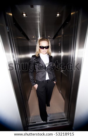 Young business woman wearing glasses using elevator at office.