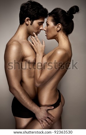 Romantic Couple In Lingerie standing sideways to camera with topless woman caressing mans cheek.